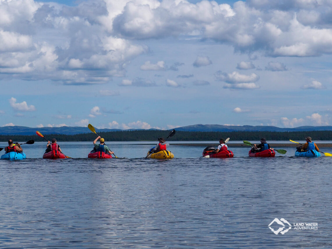 Packrafterinnen nebeneinander auf einem See in Norwegen unterwegs