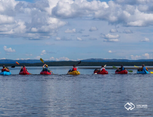 Packrafterinnen nebeneinander auf einem See in Norwegen unterwegs