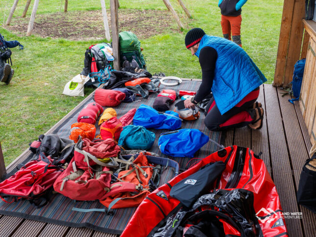 Eine komplette Multiday Packrafting Ausrüstung ausgepackt auf einer Veranda