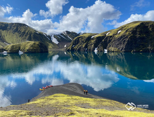 Seenlandschaft auf Island, am Ufer mehrere Packrafts und Menschen