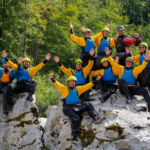 Eine Gruppe Packrafter auf einem Stein der Soca sitzend