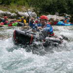 Off we go into the waves at the Advanced Course! Ein Packrafter macht sich auf den Weg in die Wellen während der Rest der Gruppe im Hintergrund wartet
