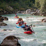 Eine Gruppe Packrafter im türkisfarbenen Wasser der Soca